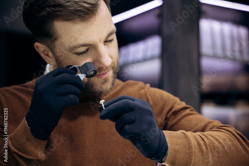 Skilled jeweler wearing gloves examining a diamond engagement ring with a loupe, ensuring quality and authenticity