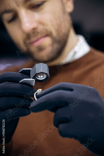 Jeweler wearing black gloves examining a diamond ring with a professional loupe, ensuring quality and precision craftsmanship