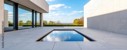 Minimalist Modern Patio Central reflection pool mirrors blue sky, framed by glass facade and white walls, connecting architecture with a panoramic outdoor nature view. modern design,