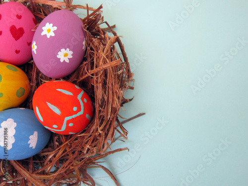         Happy Easter! Modern painted eggs inside the nest.                       