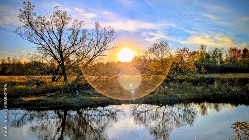 Bild auf Leinwand Halo solaire du couchant sur la rivière