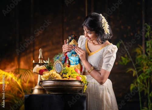 Vishu Kani festival photo Kerala girl wearing traditional dress and sanding near Vishu Kani