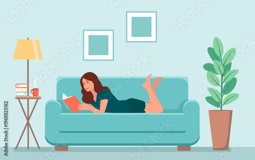A woman is lying on a sofa in a room and reading a book. 