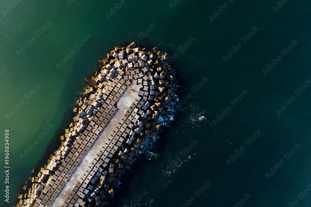 Obraz premium Aerial top down view of a concrete breakwater in the ocean The Concept of Coastal Engineering
