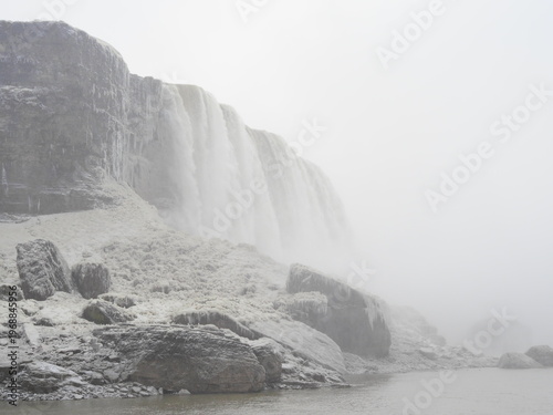 Icy riverbank with rocks and rushing winter water