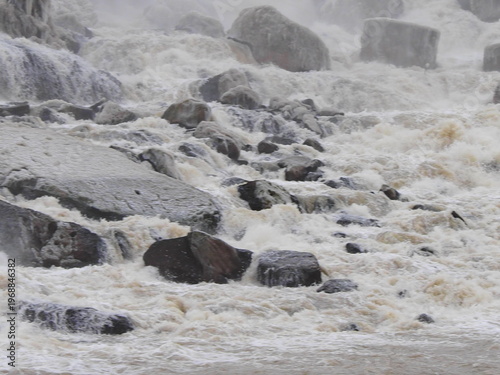 Icy riverbank with rocks and rushing winter water