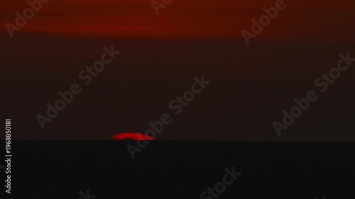 Dramatic sunset over the ocean, with a huge red sun on the horizon an ideal scene for tranquil and scenic themes