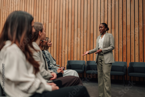 Confident black woman delivering a presentation to attentive seminar attendees. Business communication and group learning