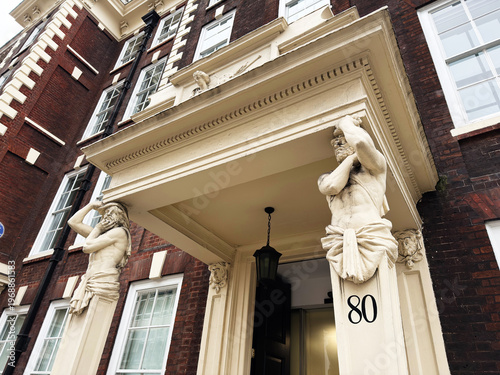 Obraz na plátně Historic London, UK building entrance with classical atlantes statues flanking d