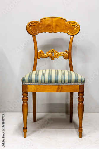 Elegant vintage wooden chair with a striped cushion perfect for classic home decor