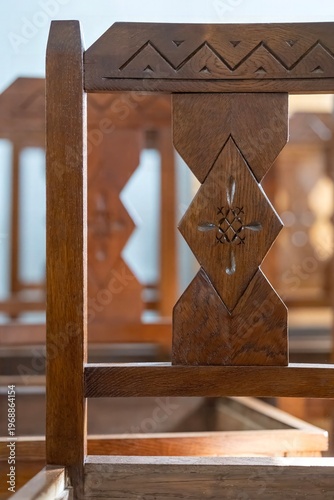 Wooden chair with intricate designs showcasing craftsmanship in a cozy indoor setting filled with warm light