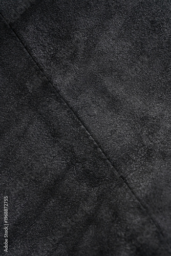 Crumpled black suede textured vertical background with diagonal seam
