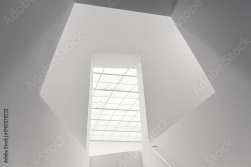 Modern minimalist skylight with geometric grid pattern in white architectural interior space looking upward