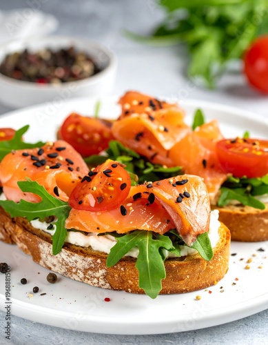 Salmon toasts with cream cheese, arugula, tomato, and black sesame seeds on a white plate