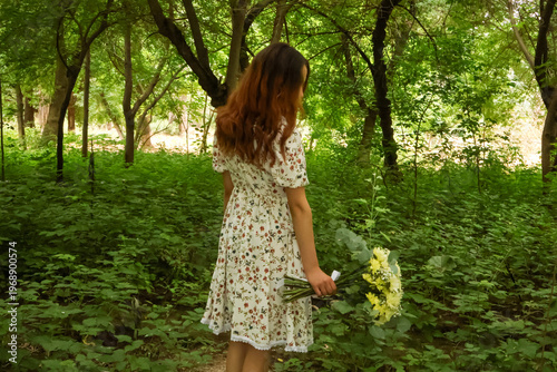 Back view of a girl walking into the forest