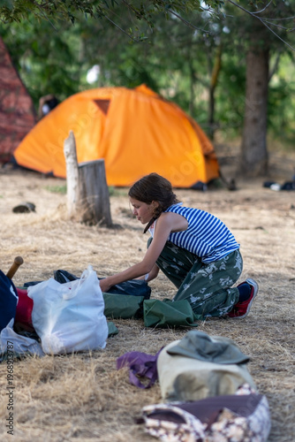A girl folds a tent