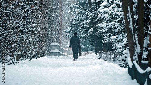 Elegant Male Gentelman with Walking Down City Park Walkway Alley Covered in Fresh Thick Snow on Beautiful Winter Day