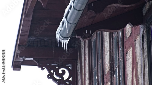 Massive Long Dangerous Icicle Hanging from Frozen Rain Gutter Posing Injury Hazard for Pedestrians