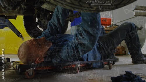The mechanic is examining a car at a repair garage