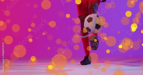 Animation of lens flares over low section of african american player dribbling soccer ball
