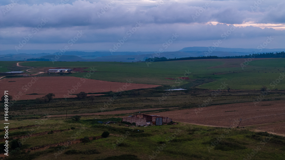 Fototapeta premium Dramatic African Landscape with Colorful Sky and Rural Fields