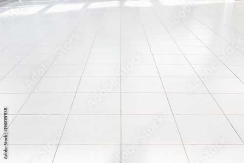 Clean, pristine and well maintained white ceramic tile floor in perspective view, bright smooth surface with subtle reflections. Ideal for product display backgrounds, durability and clean aesthetic.