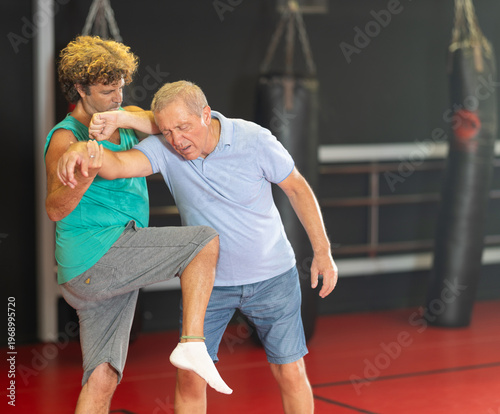 Foto Purposeful male pupil clash with training manager during self-defense lesson, re