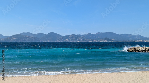 Azure Coastline View Serene Beach, Turquoise Water, and Distant Mountains. Summer Vacation
