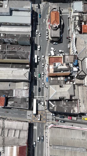 Imagem aérea vertical de cruzamento com veículos em circulação mostrando fluxo de trânsito e mobilidade urbana em ambiente urbano