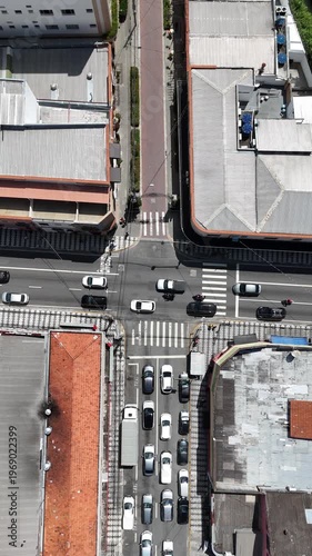 Vista aérea vertical de cruzamento urbano com fluxo de veículos destacando trânsito, mobilidade e infraestrutura viária em cidade