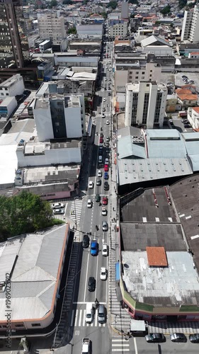Vista aérea vertical de cruzamento urbano com veículos circulando, destacando mobilidade, trânsito e fluxo de carros em área urbana movimentada
