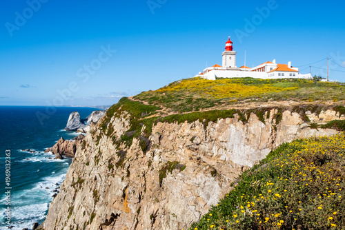 Cabo da Roca lighthouse on cliff above Atlantic ocean in Sintra, Lisbon district, Portugal. Most western point of continental Europe. Beautiful seascape on sunny day