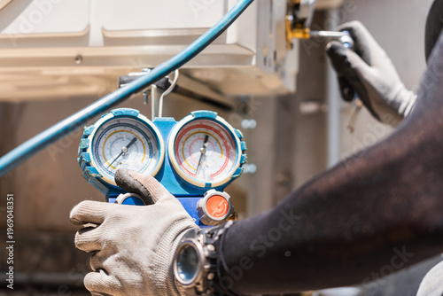 Cuadro en lienzo Air conditioning technician hands in gloves holding manifold gauge to check pres