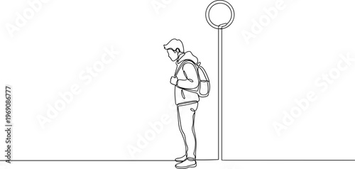 Young man with backpack standing alone.