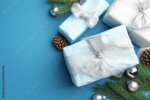 Christmas composition with gifts and decor on light blue background, flat lay. Space for text
