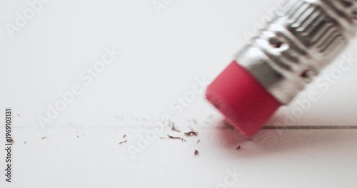 Erasing a pencil line with a pink eraser and creating a mess on white paper. Conceptual bad idea, fixing problems, failure or mistake, wrong decision, or to remove an error. Back to School supplies.