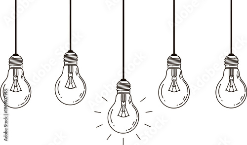 Black and white light bulbs hanging on cords with one glowing