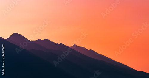 Golden Horizon: Layered Mountain Silhouettes at Sunset