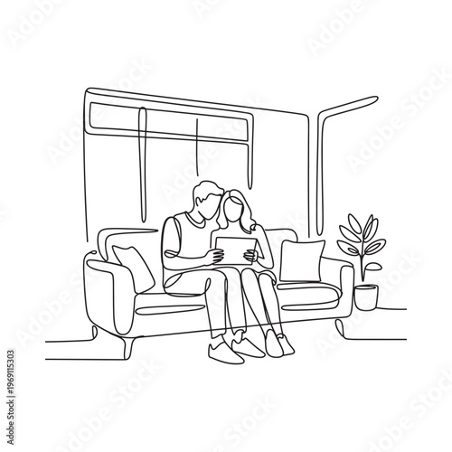 Couple relaxing on a sofa viewing content on a digital tablet