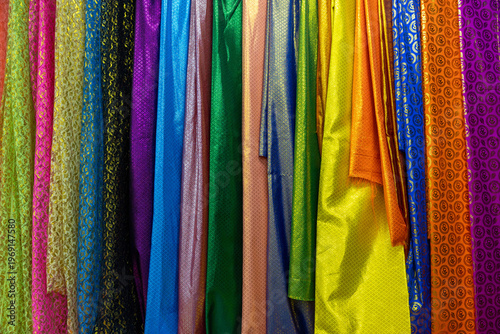 Bright multicolored cut pieces of fabric displayed in thai market. Full frame background
