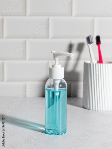 Liquid soap dispenser mockup with toothbrushes in minimal bathroom interior