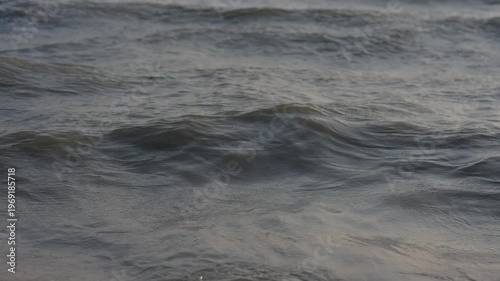 Calming sea waves reflecting sunset light