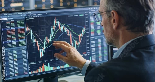 Analyst reviews stock market data on computer screen