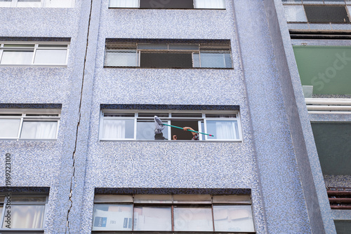 Curitiba, Brasil - Mujer limpiando la ventana de su apartamento.