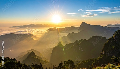 A breathtaking panoramic view captures a vibrant sunrise over a range of majestic mountains shrouded in a sea of clouds, creating a stunning display of natural beauty.