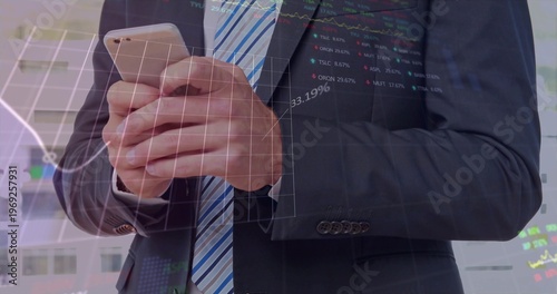 Executive in dark suit striped tie holding smartphone at office windows, with financial overlays