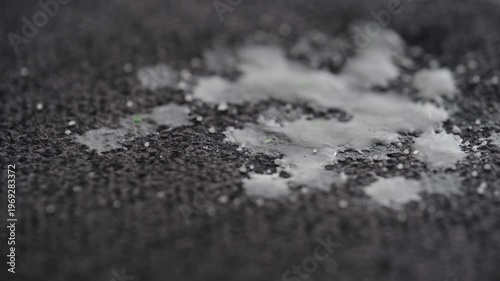 White candle dripping wax on to cloth or furniture upholstery on a gray background, at a cozy location. Concept of everyday life problem and home cleaning