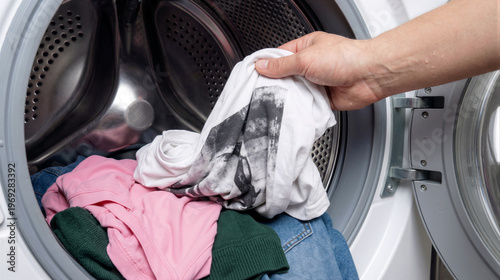 A person hand is seen placing colorful laundry into an open front load washing machine drum during daily house chores. Generative AI.