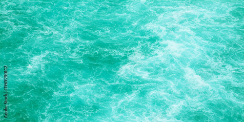 Abstract turquoise water flows with frothy waves. A beautiful photorealistic abstract of nature's beauty
