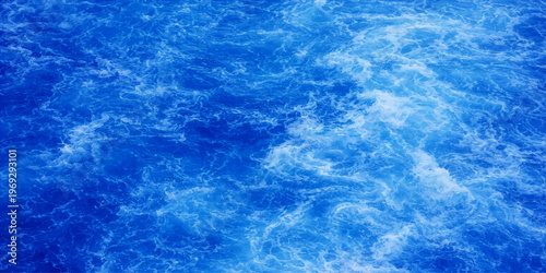 Abstract an expanse of azure water teems with swirling waves, a dance of texture and motion, full of depth. A calming, dynamic display of oceanic wonder.